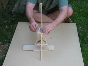 Trebuchet in resting (vertical) position.  The counterweight is directly below the throwing arm at its lowest energy.
